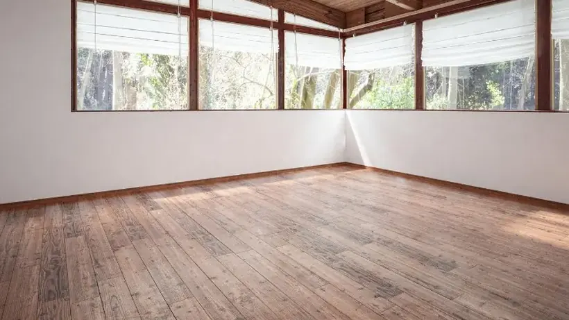 Salón vacío con suelo de madera tras retirar los muebles